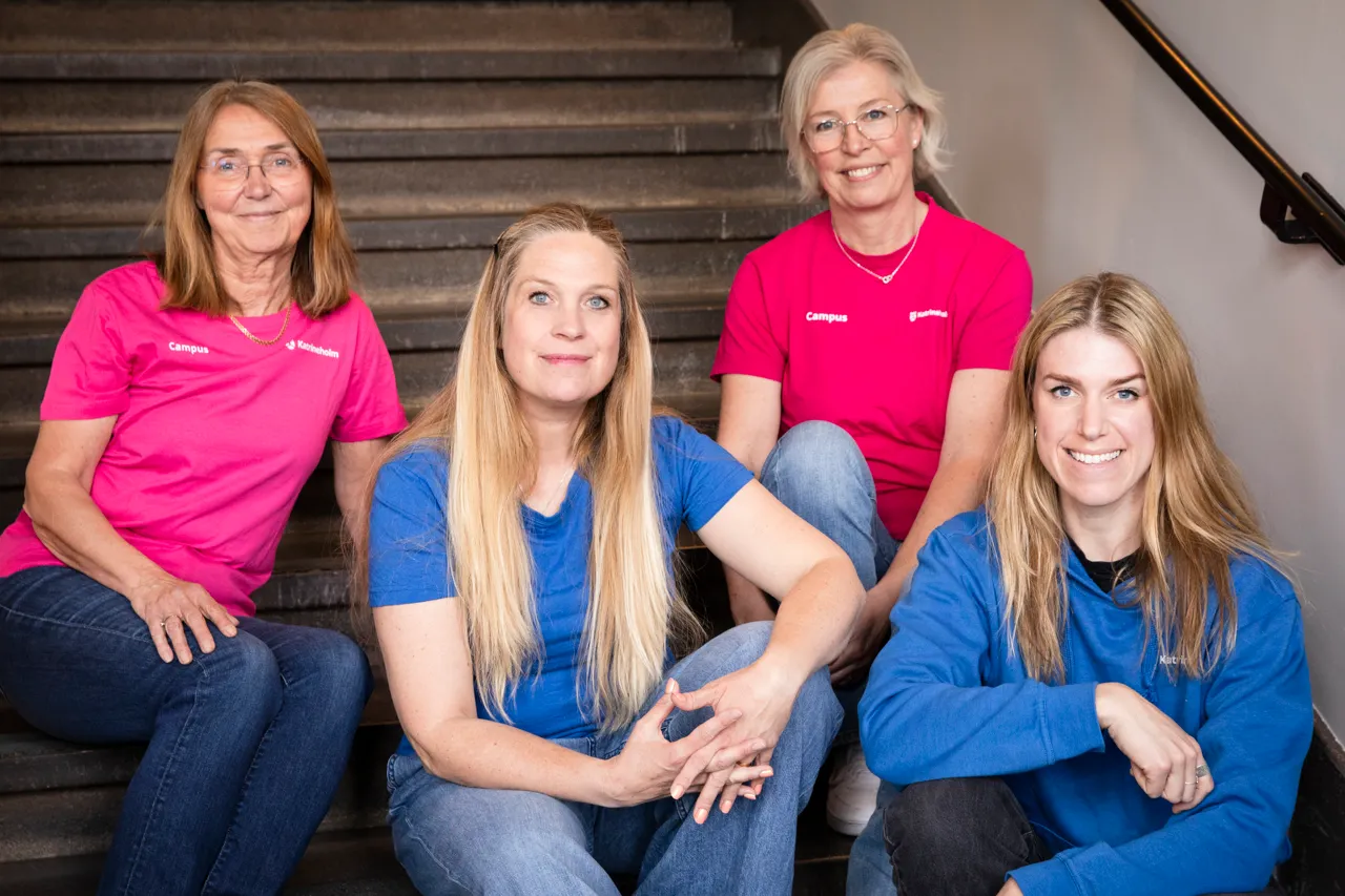 En grupp kvinnor som sitter högst upp på en trappa.