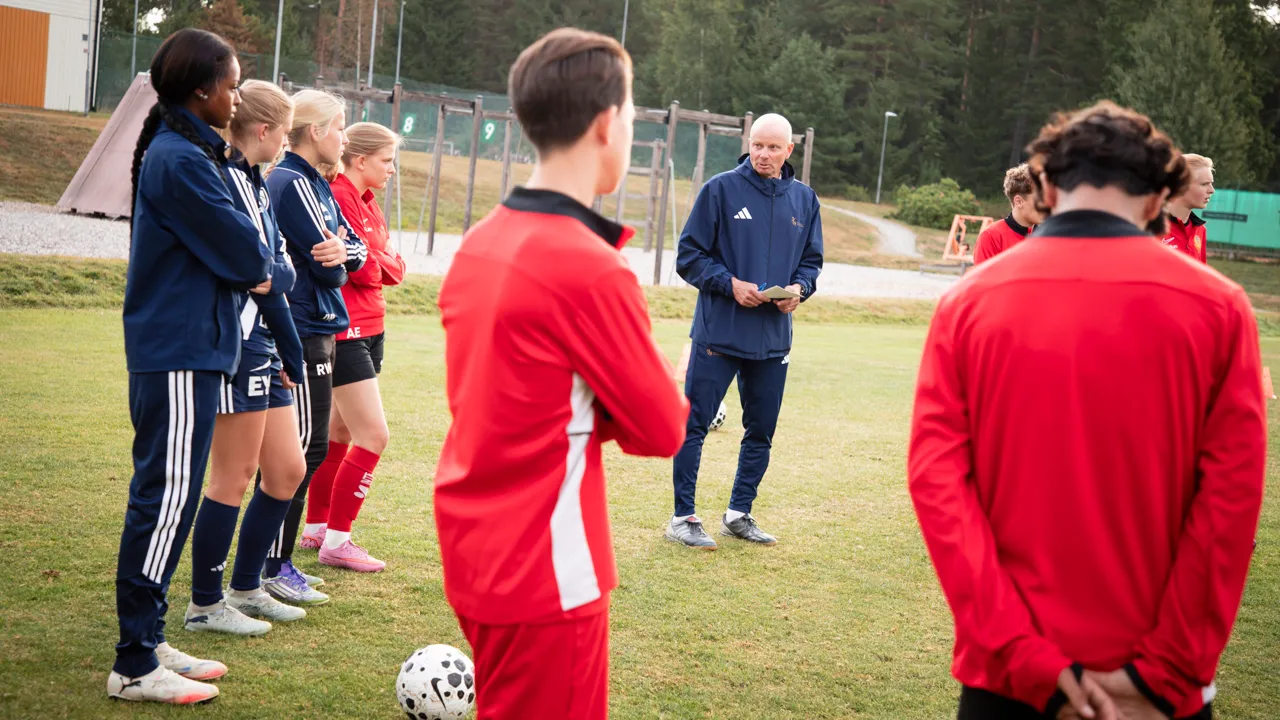 En grupp människor som står runt en fotboll.