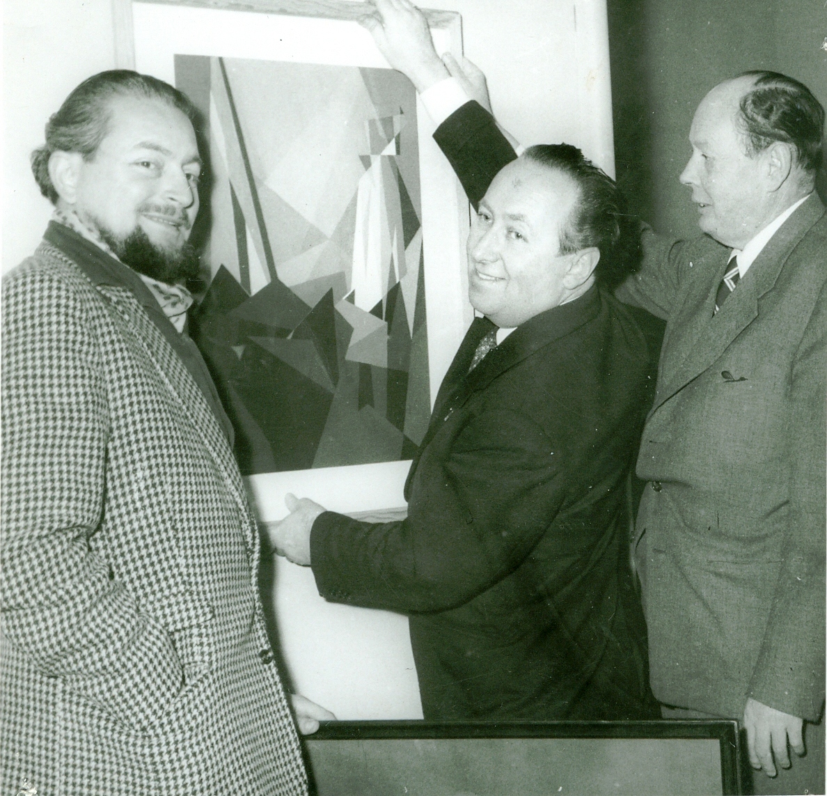 Svartvit bild på tre personer som står framför en tavla. 