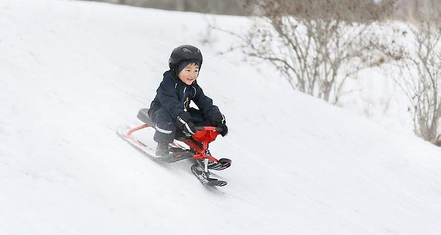 Ett barn åker snowracer